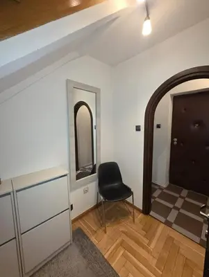 a room with a black chair and a mirror at Chill Apartment with Jacuzzi in Kraków
