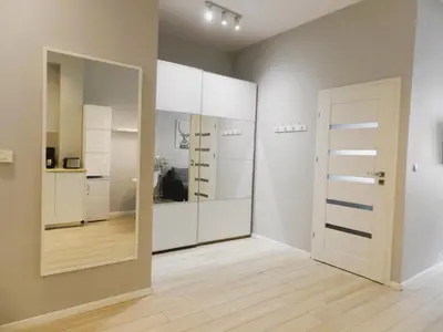 a room with white cabinets and a mirror at Apartament Donnka in Kraków