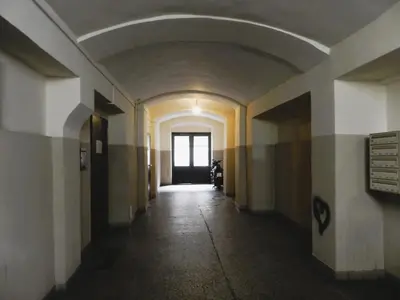 an empty hallway in an old building with a window at Apartament Donnka in Kraków