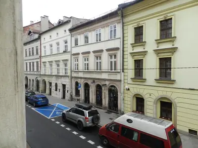 a city street with cars parked in front of buildings at Apartament Donnka in Kraków