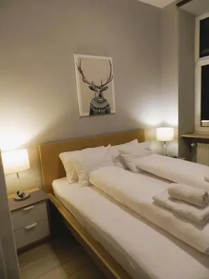 a bedroom with a large bed with a deer head on the wall at Apartament Donnka in Kraków