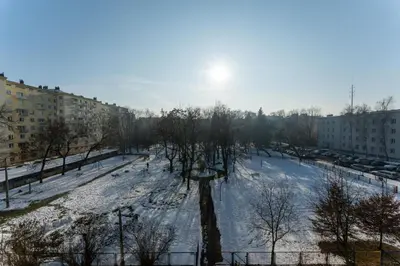a snow covered park in a city with buildings at Nowa Huta Charming Apartment by BookingHost in Kraków