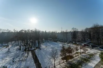 a view of a snow covered street with cars at Nowa Huta Charming Apartment by BookingHost in Kraków