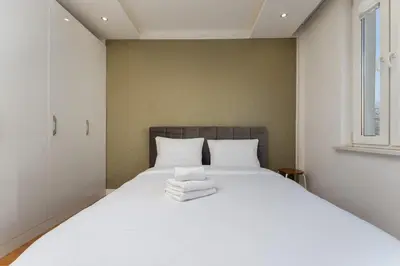 a bedroom with a large white bed with towels on it at Nowa Huta Charming Apartment by BookingHost in Kraków
