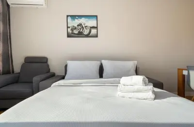 a bed with two white towels on top of it at Nowa Huta Charming Apartment by BookingHost in Kraków