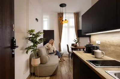 a woman sitting in a chair in a kitchen at L23 Boutique by Downtown Apartments in Kraków