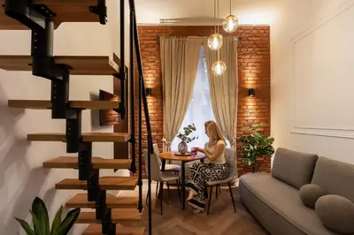 a woman sitting at a table in a living room at L23 Boutique by Downtown Apartments in Kraków