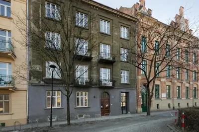 a large brick building with trees in front of it at L23 Boutique by Downtown Apartments in Kraków