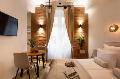 a bedroom with a bed and a table and a window at L23 Boutique by Downtown Apartments in Kraków