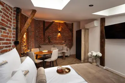 a hotel room with a bed and a dining room at L23 Boutique by Downtown Apartments in Kraków