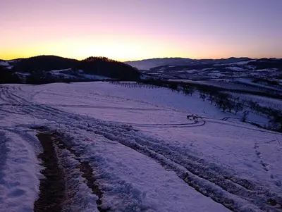 an aerial view of a snow covered field at sunset at Domek Gruszkowy Wzorek in Łącko