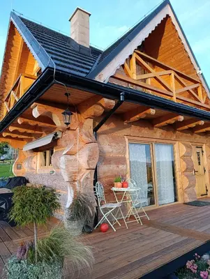 a log cabin with a deck and a table at Domek Gruszkowy Wzorek in Łącko