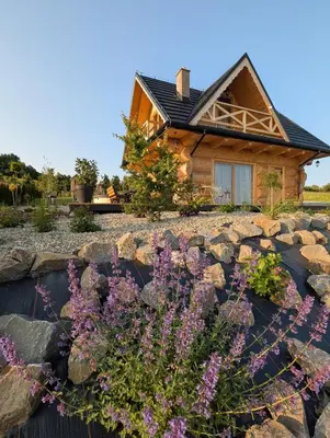 a house with a rock garden in front of it at Domek Gruszkowy Wzorek in Łącko