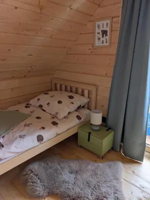 a bedroom with a bed in a log cabin at Domek Gruszkowy Wzorek in Łącko