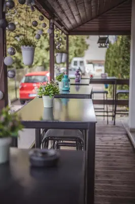 a black chair next to a table and a glass chair at 4 Couples Hostel in Kraków