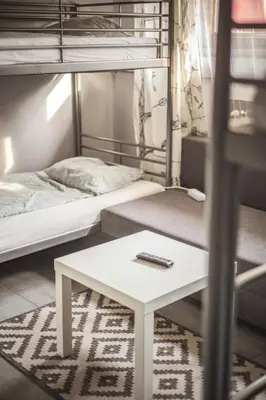 a room with two bunk beds and a window at 4 Couples Hostel in Kraków
