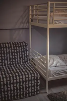 a bed with a pillow in front of a window at 4 Couples Hostel in Kraków