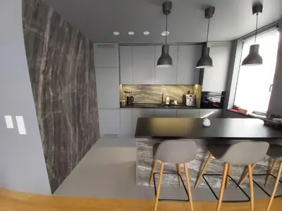 a kitchen with a black counter and two chairs at Urban Oasis with a garage in Kraków
