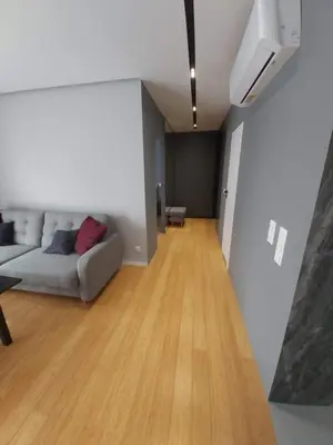 a living room with a couch and a wooden floor at Urban Oasis with a garage in Kraków