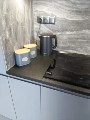a kitchen counter with two cups on a stove at Urban Oasis with a garage in Kraków
