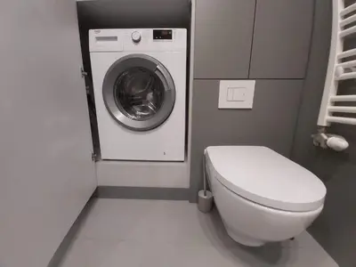 a bathroom with a toilet and a washing machine at Urban Oasis with a garage in Kraków