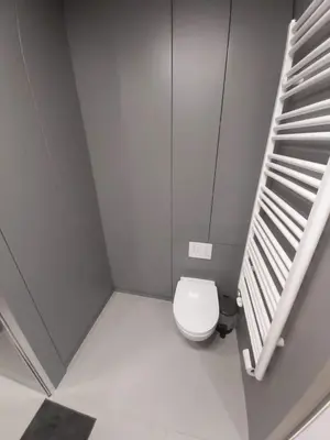a small bathroom with a toilet and a staircase at Urban Oasis with a garage in Kraków