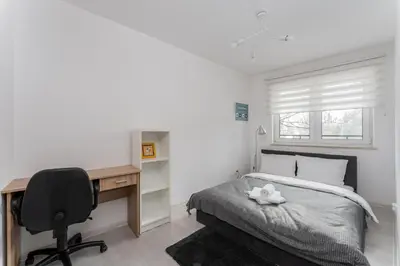 a bedroom with a desk and a bed and a chair at Bronowice Modern Apartment by BookingHost in Kraków