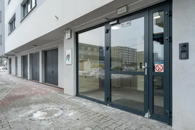 a building with sliding glass doors on a street at Bronowice Modern Apartment by BookingHost in Kraków