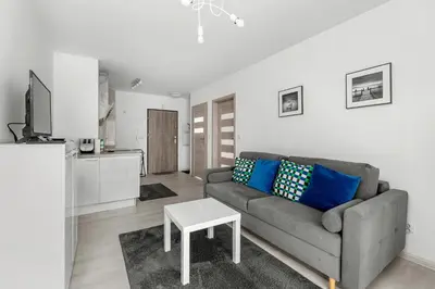 a living room with a couch and a table at Bronowice Modern Apartment by BookingHost in Kraków