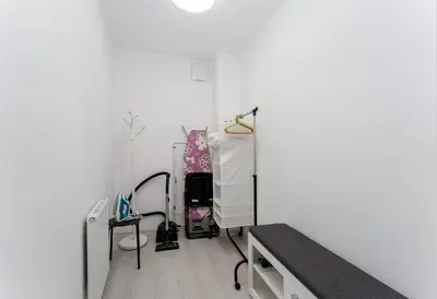 a room with a bed and a white wall at Bronowice Modern Apartment by BookingHost in Kraków