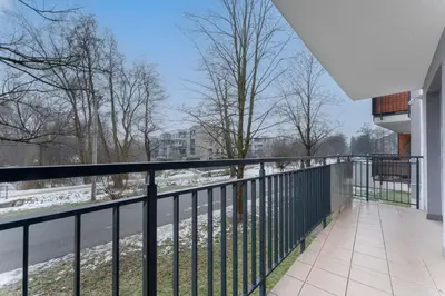 a balcony with a view of a snowy street at Bronowice Modern Apartment by BookingHost in Kraków