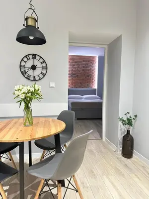 a dining room with a table and chairs and a clock at Native Apartments Starowiślna 33A in Kraków