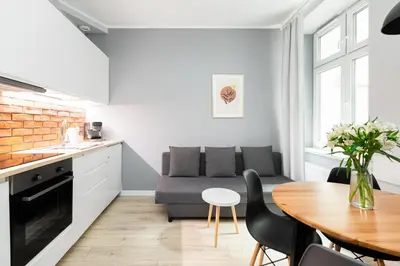 a kitchen and living room with a couch and a table at Native Apartments Starowiślna 33A in Kraków