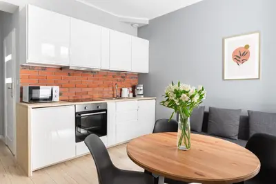 a kitchen and a table with a vase of flowers at Native Apartments Starowiślna 33A in Kraków
