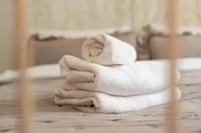 a pile of towels sitting on top of a bed at Heart of Cracow Old Town Apartment by BookingHost in Kraków