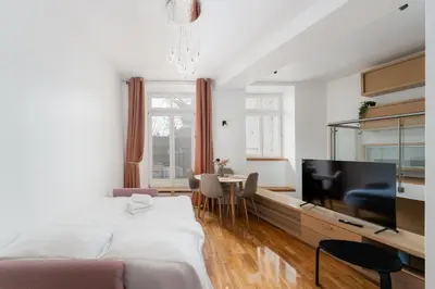 a bedroom with a bed and a flat screen tv at Heart of Cracow Old Town Apartment by BookingHost in Kraków