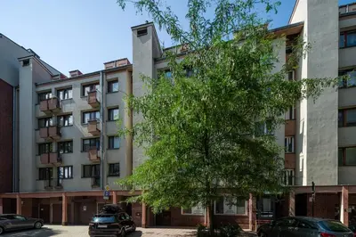 an apartment building with a tree in front of it at Unique riverside treasure in Kraków