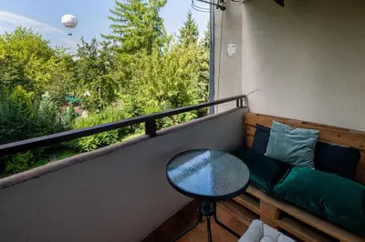 a balcony with a couch and a table and a window at Unique riverside treasure in Kraków