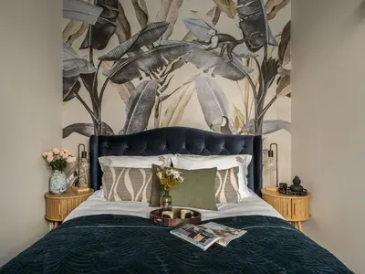 a bedroom with a blue bed with a tree mural at Bohemian Suites by Fragola Apartments in Kraków