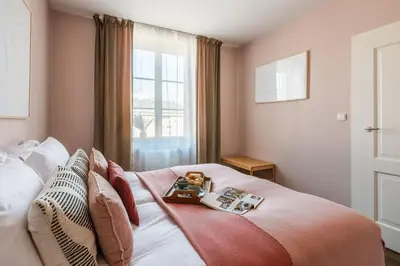a bedroom with a bed with a green headboard at Bohemian Suites by Fragola Apartments in Kraków