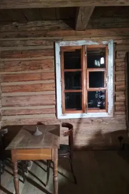 a wooden cabin with a table and a window at Holiday Home mit Wasserblick by Interhome in Zawada
