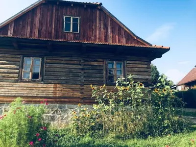 an old wooden house with flowers in front of it at Holiday Home mit Wasserblick by Interhome in Zawada