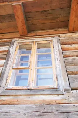 a window in the front of a wooden house at Holiday Home mit Wasserblick by Interhome in Zawada