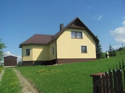 a house on a grassy hill with a fence at Holiday Home Haus Sonne by Interhome in Nowe Rybie