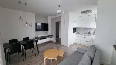 a living room and kitchen with a couch and a table at Apartment Cure in Kraków