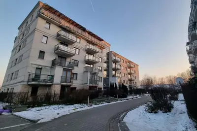 an apartment building on a snow covered street at Apartment Cure in Kraków