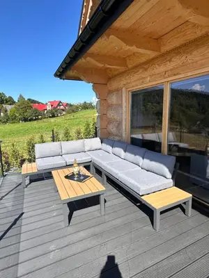 a patio with a couch and a table on a deck at Babiogórski Azyl & SPA in Zawoja