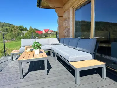 a couch and a table on a deck at Babiogórski Azyl & SPA in Zawoja