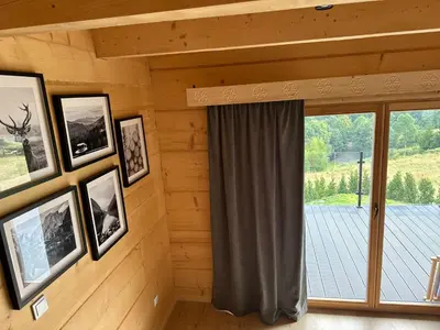 a room with pictures on the wall and a window at Babiogórski Azyl & SPA in Zawoja