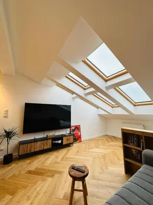 a living room with skylights and a flat screen tv at Sky Studio Old Town in Kraków